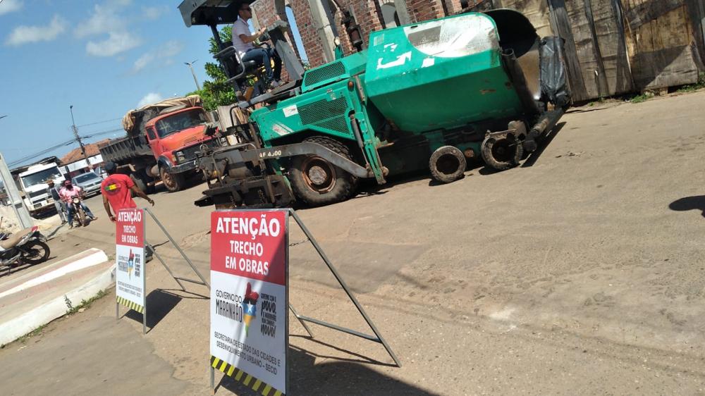 Máquinas aplicando camada asfáltica na rua Coelho Neto, centro de Itapecuru Mirim