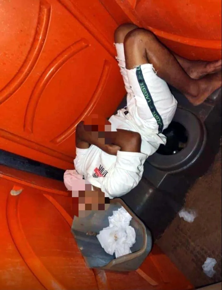 Folião dormindo dentro de um banheiro químico no final do carnaval 2025. Imagem: Reprodução redes sociais.